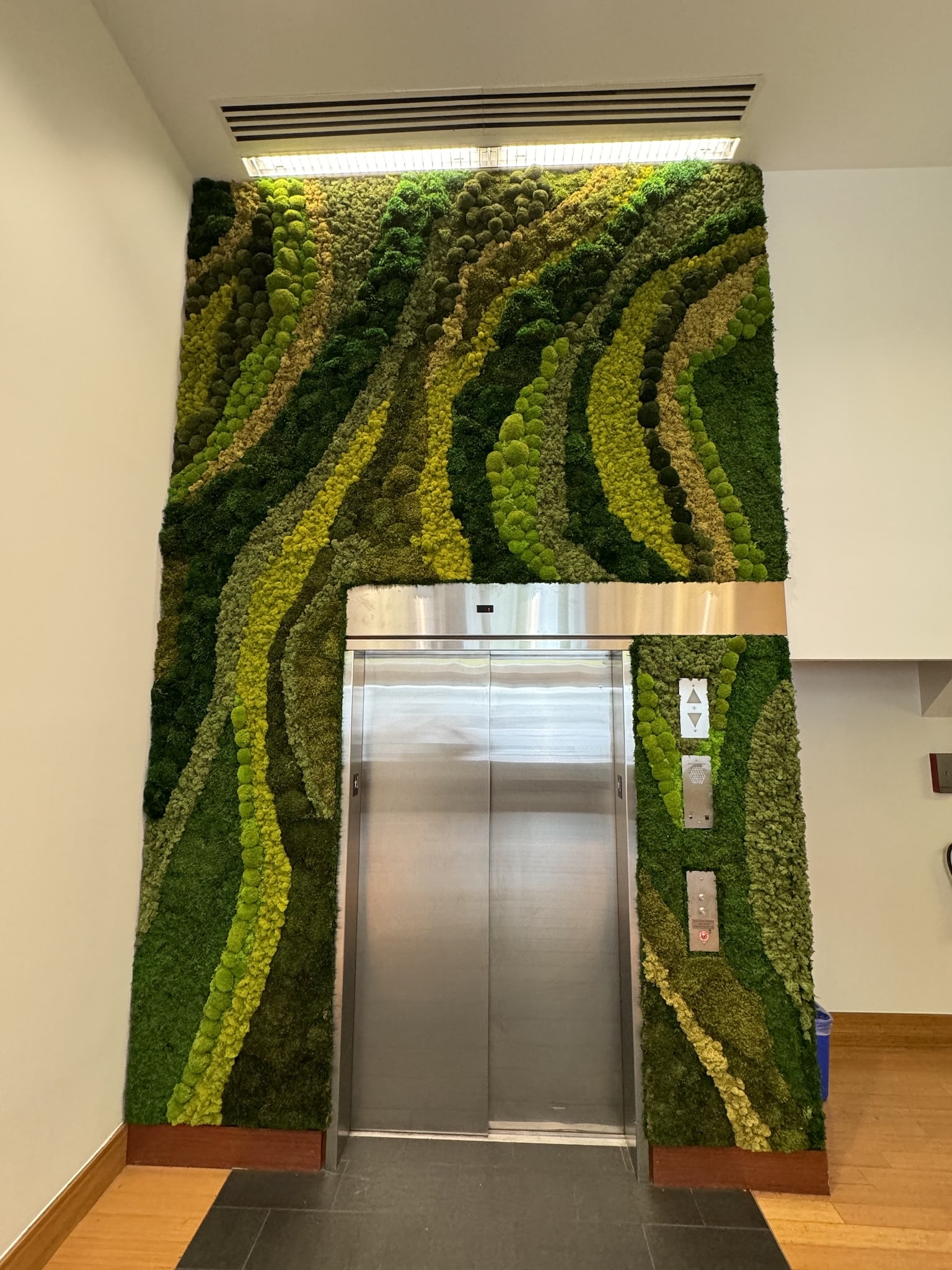 sculpted moss wall art surrounding elevator in commercial space
