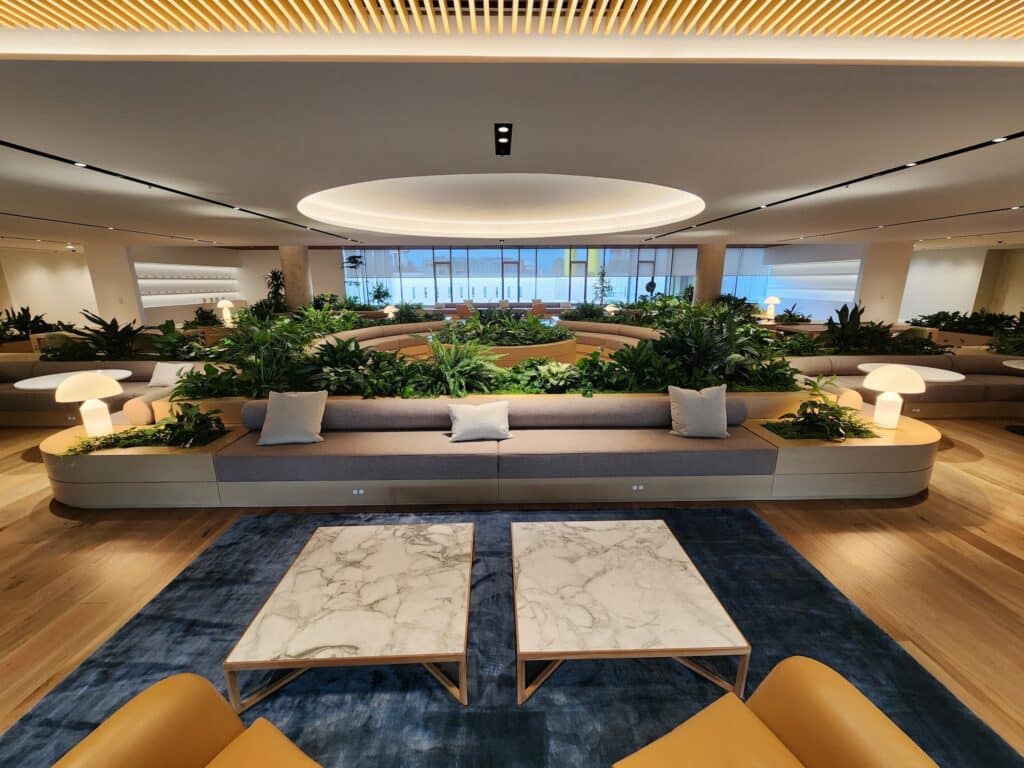 Contemporary office lounge with abundant indoor plants integrated into modular wood planters.